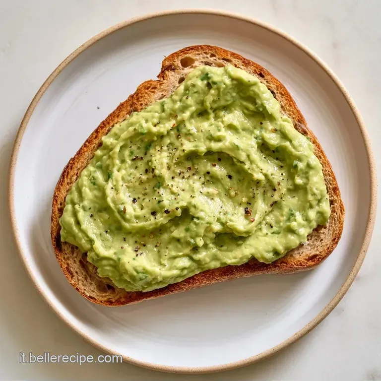 Avocado tagliati a met&agrave; su un piatto di ceramica bianca, guarniti con formaggio fresco e un filo d'olio dorato.