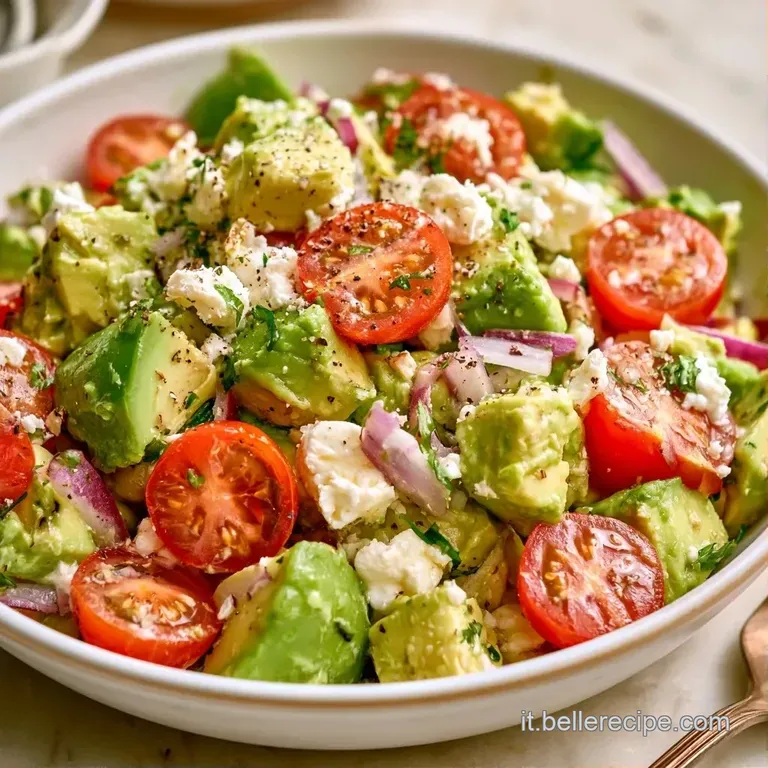 Composizione elegante di avocado cremoso e feta bianca su letto di foglie verdi, rifinita con un filo d'olio dorato.